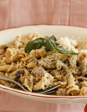 a server at Embr holding a plate of pasta