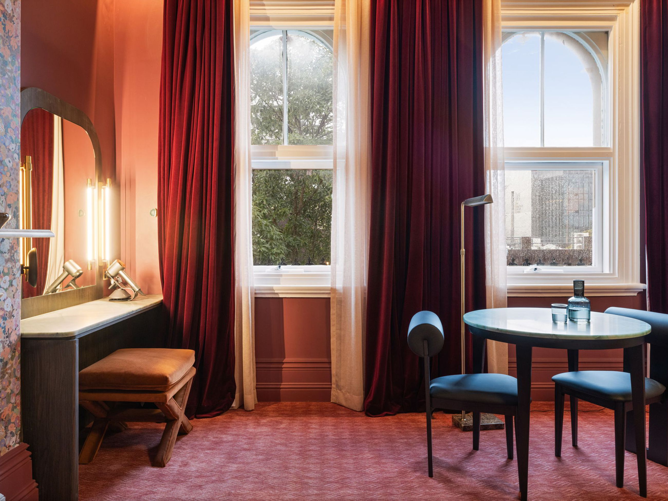 Nook with red velvet curtains and chairs at Medusa Hotel