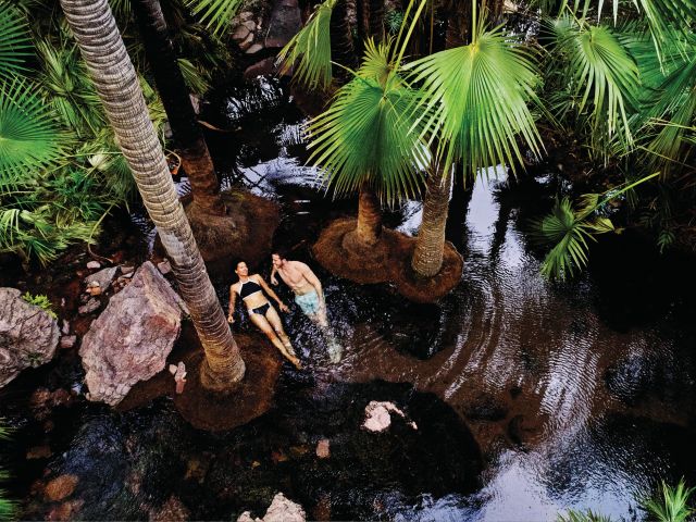 A couple swimming at Zebedee Springs, El Questro Wilderness Park, WA