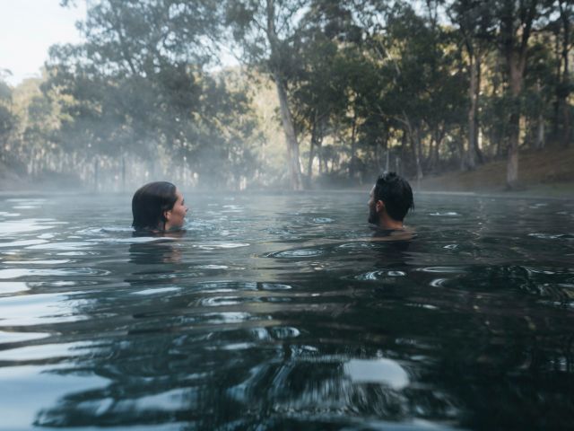 A couple swimming at Yarrangobilly Caves Thermal Pool.