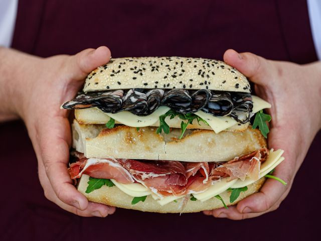 a hand holding a big burger at Embr, Echuca Moama