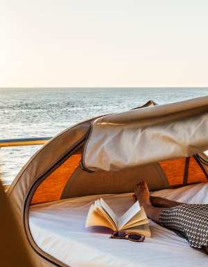 Woman lying on Reefsleep bed with a book at Reefworld on Great Barrier Reef