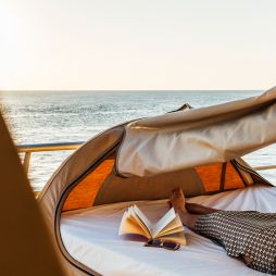 Woman lying on Reefsleep bed with a book at Reefworld on Great Barrier Reef