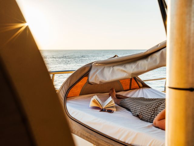 Woman lying on Reefsleep bed with a book at Reefworld on Great Barrier Reef
