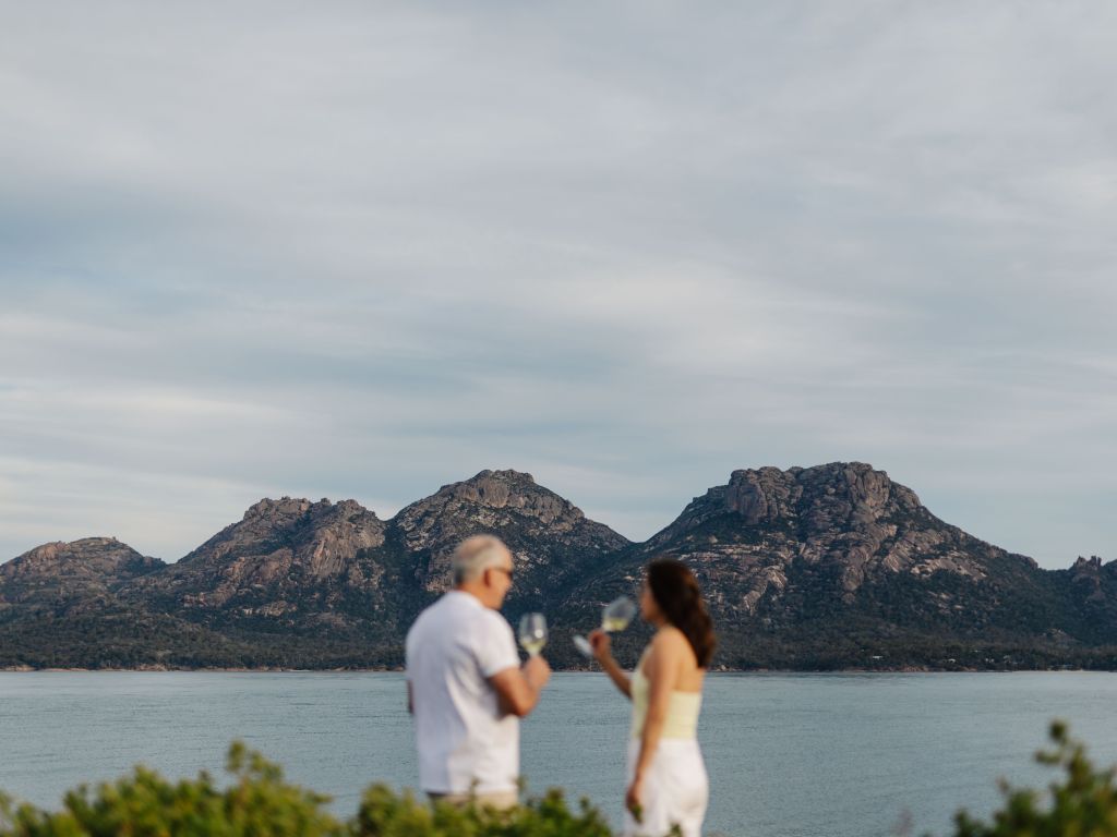 Couple drinking wine outside on Picnic Island in Tasmania