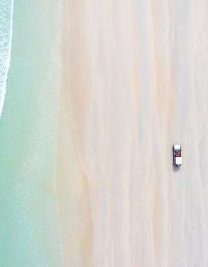 car on cable beach at sunrise