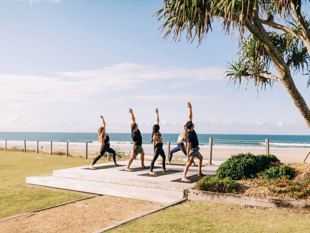 Guests doing yoga by the beach at Elements of Byron