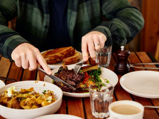 A person slicing food from a plate at the Meredith Farm Store.