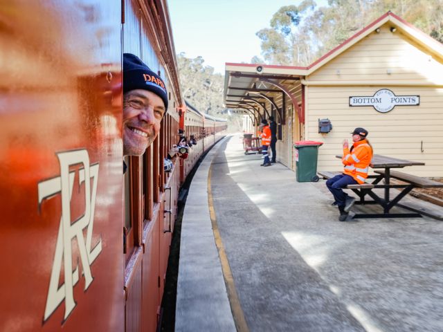 A man sticking his head out of the Zig Zag Railway train