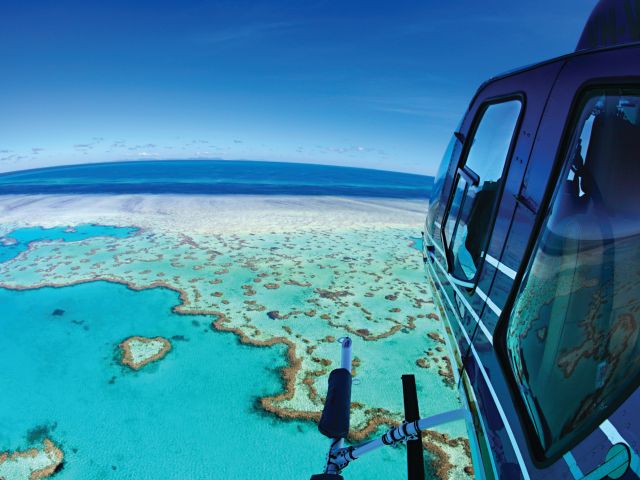 A helicopter soaring above the iconic Heart Reef.