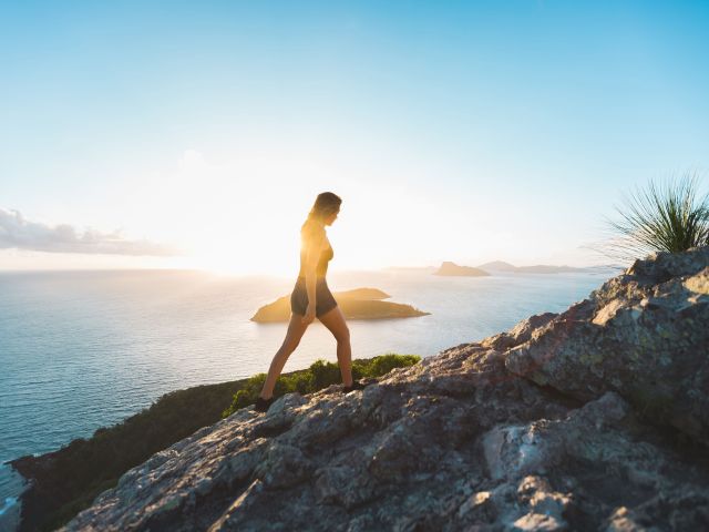 A woman hiking along the Passage Peak trail on Hamilton Island.