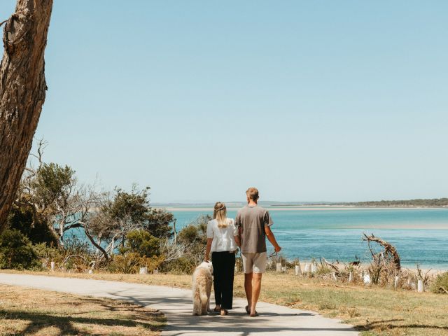 Couple walking dog on Inverloch Shared Pathway on the coast