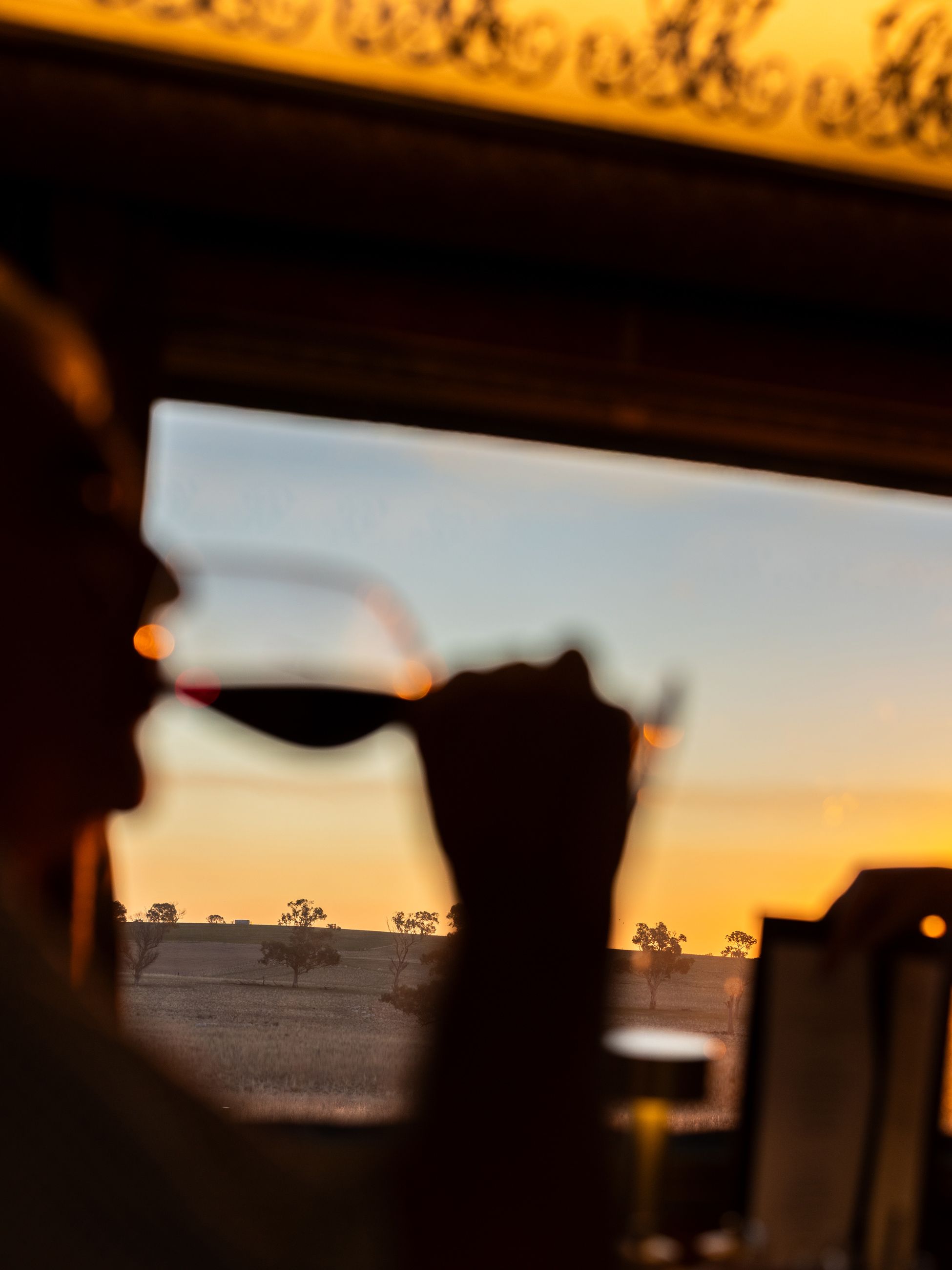 Guest drinks a glass of wine at sunset onboard