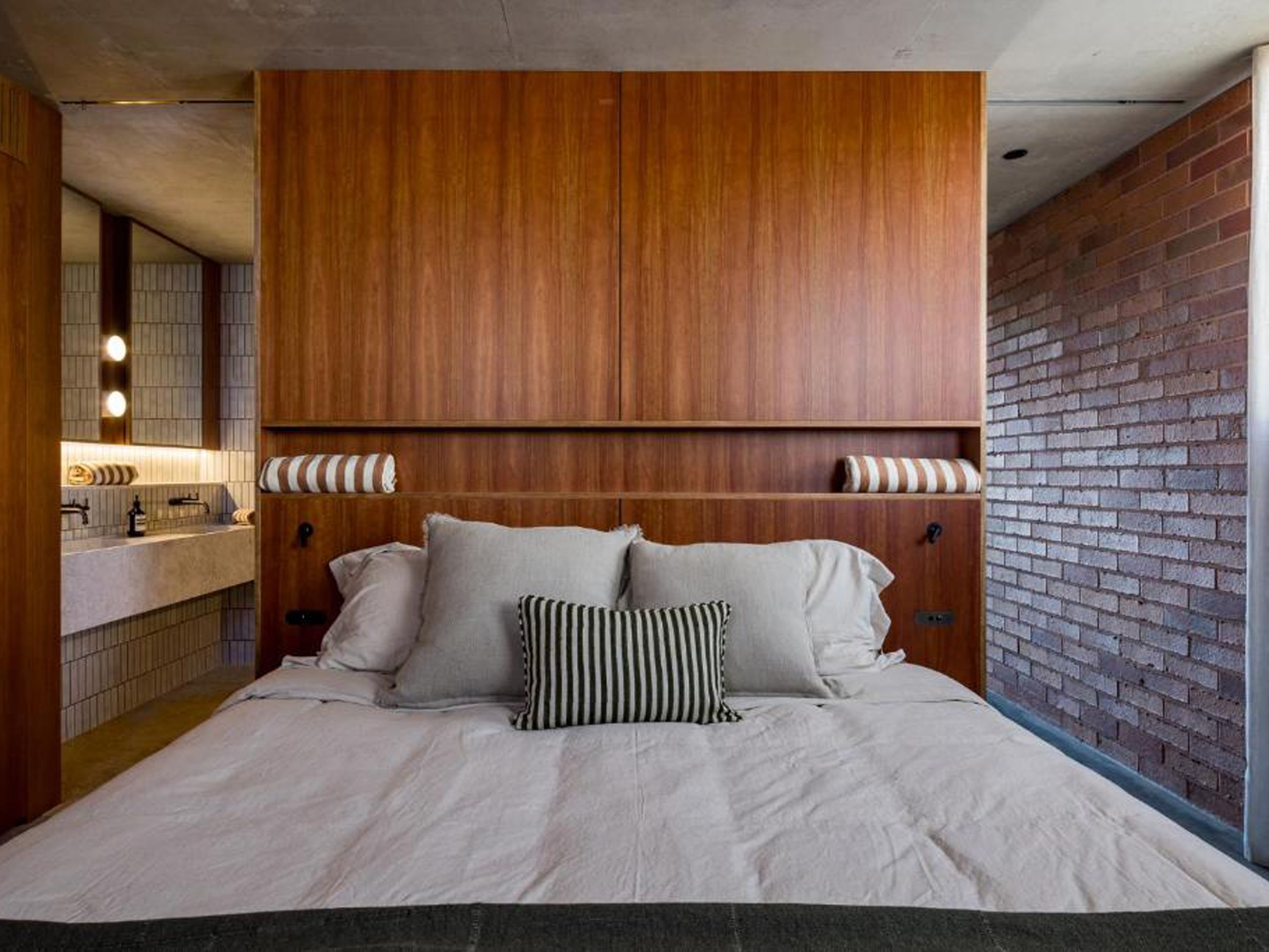 A modern bedroom with a timber headboard