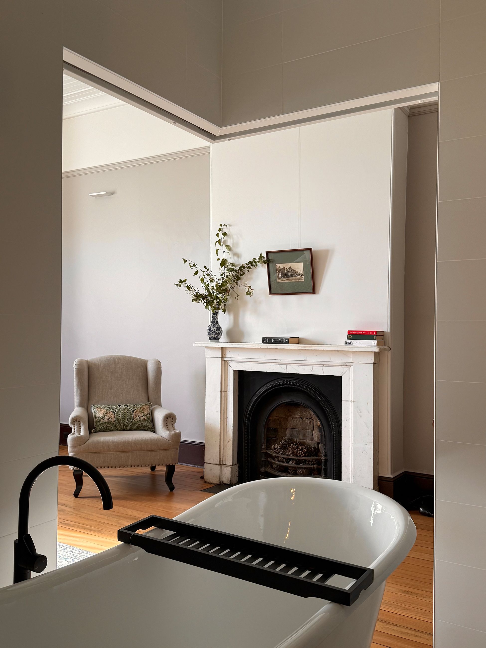 A freestanding bath facing a fireplace