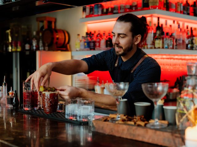 A bartender makes cocktails at Astra Falls Creek