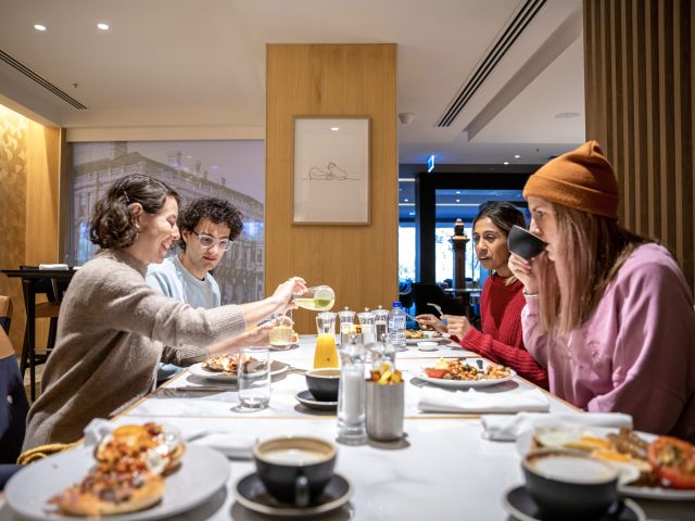 Friends enjoying a hearty breakfast together at The Cliveden Buffet Breakfast before a day of exploring Melbourne.