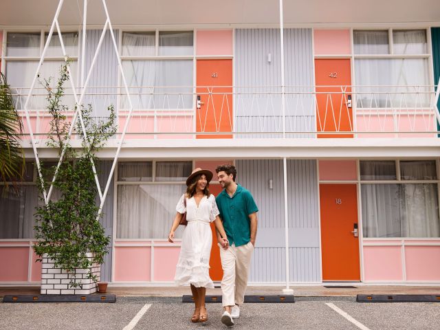 Couple standing outside the retro inspired Astor Hotel Motel in Albury