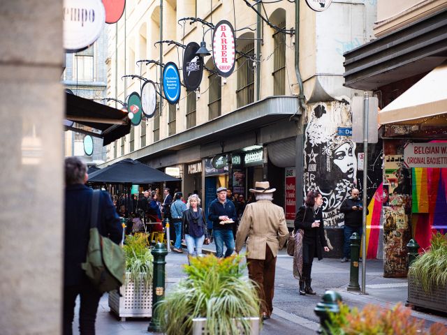 People strolling through Melbourne's iconic Degraves Street, lined with bustling cafés and laneway charm.