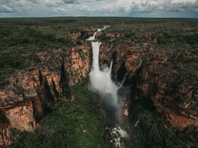Jim Jim Falls from above during a wet season helicopter tour. Covering nearly 20,000 square kilometres, Kakadu National Park is teeming with wildlife, home to important Aboriginal rock art sites, and takes in diverse and exotic landscape.