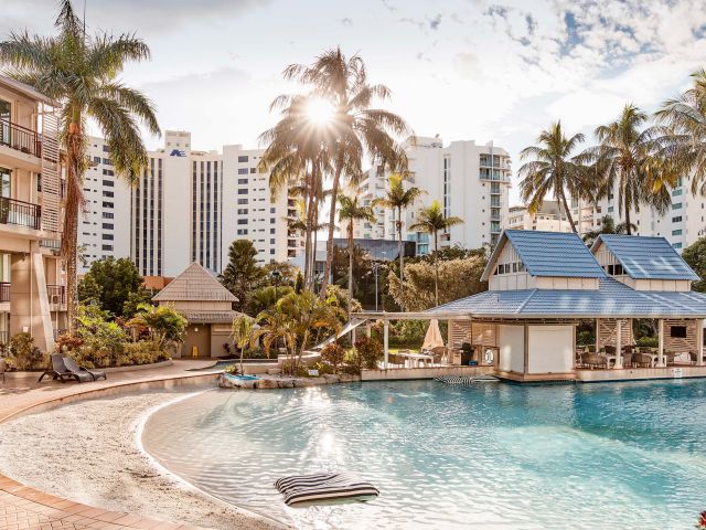 The sandy lagoon pool at Novotel Cairns Oasis Resort, featuring a real sand beach for family fun.