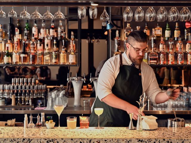 A bartender prepares handcrafted cocktails.