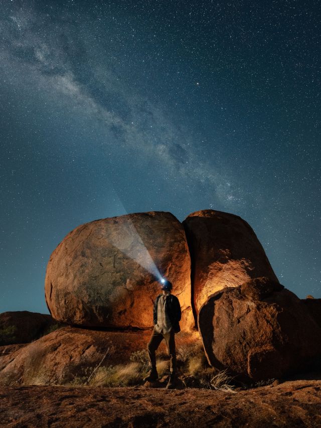 a stargazer wearing a headtorch and looking at the stars