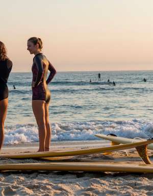 Women heading out for a morning surf at Cabarita Beach, a place on the tweed which was named in Expedia's Destinations Of The Year 2027