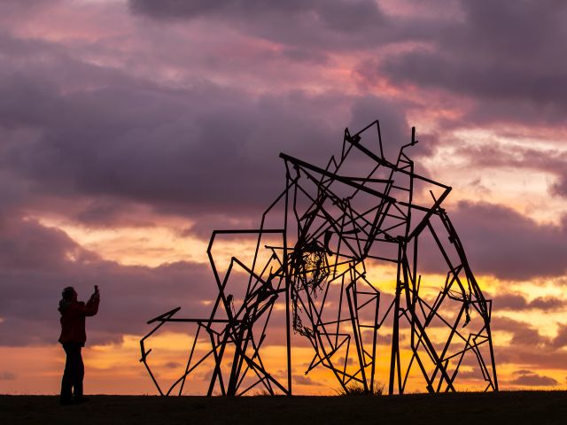 Harrie Fasher’s steel sculpture Unveiling the Edges of the Sky silhouetted against a sunset sky at Sculpture by the Sea, Bondi